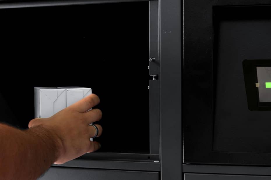 Pessoa utilizando um smart locker para retirada de encomendas, destacando a interface digital com opções de entrega e retirada, oferecendo conveniência e segurança no armazenamento de pacotes.