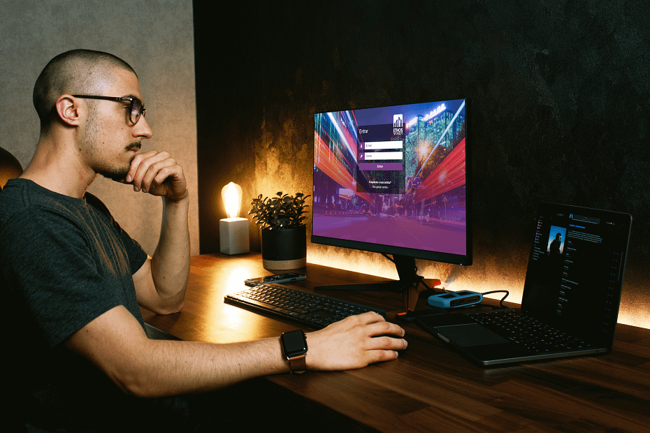 Pessoa em frente ao computador analisando software para condomínio