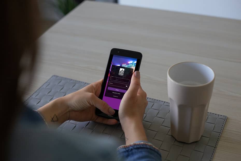 Mulher utilizando o aplicativo Ethos Vivet, uma solução integrada para condomínios, no celular.